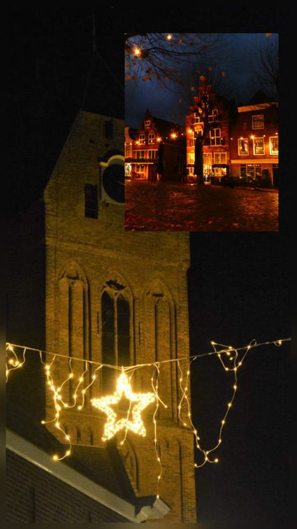Verlichte kerktoren en historische panden in Oudewater, sfeervol versierd met kerstverlichting tijdens de Lichtjesroute in het Groene Hart van Holland.