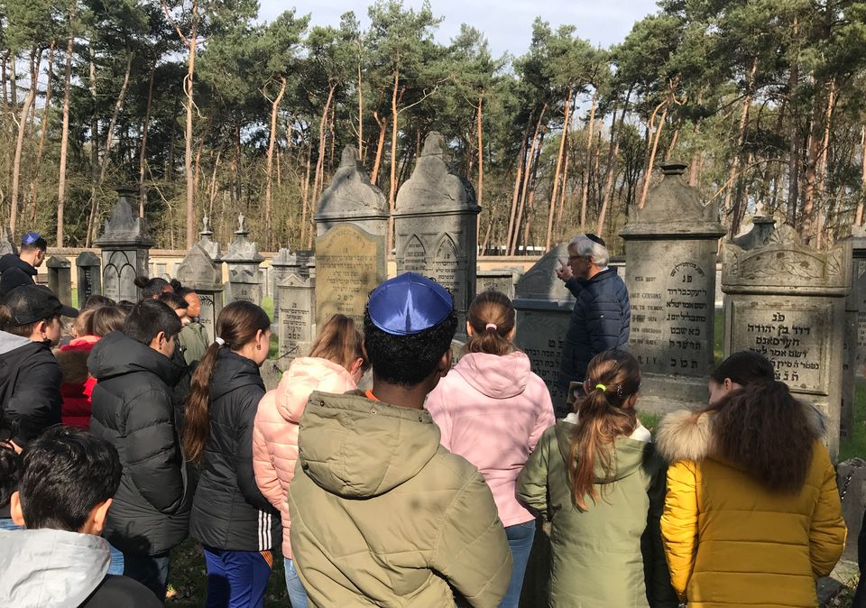 Bezoekers luisteren naar de toelichting van een gids tijdens een rondleiding over de Joods begraafplaats in Oisterwijk