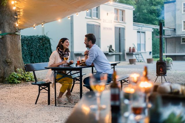 Een stel zit op het terras een biertje te drinken.