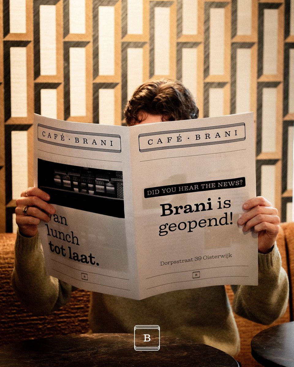 Man met krant met op voorkant nieuws dat Brani is geopend