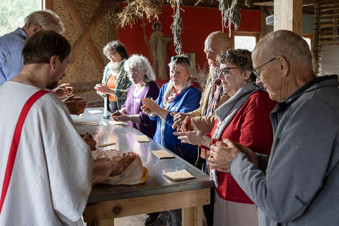 Deelnemers aan een statafel met een klompje klei, om zelf een aardewerken kommetje te maken.