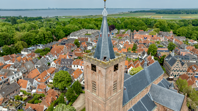 Een luchtfoto van de toren van de Grote Kerk in Naarden met op de achtergrond Naarden-Vesting.
