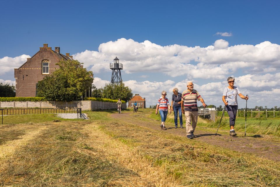 Vier mensen wandelen over Schokland