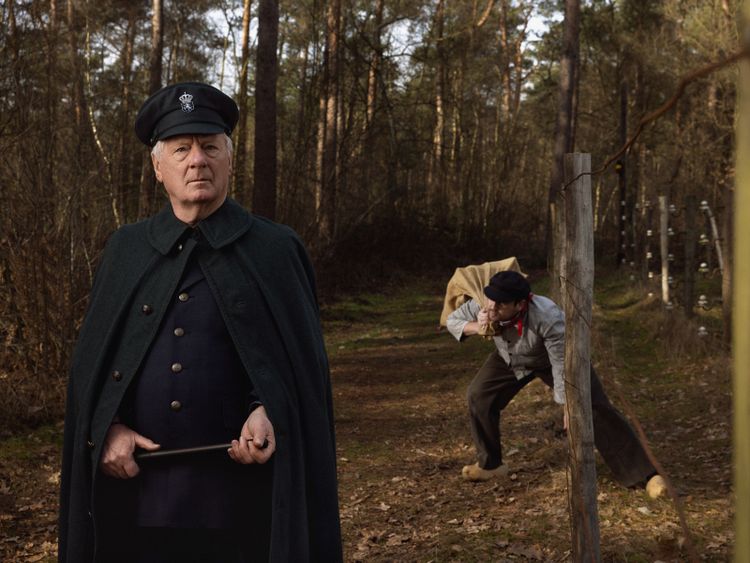Een smokkelaar en commies bij de grensovergang met prikkeldraad