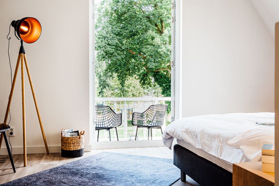 B&B kamer met bed en balkon met met zwarte stoelen.