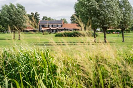 Landelijk uitzicht op Buitenplaats Kameryck in het Groene Hart, met uitgestrekte groene velden, ruisende bomen en het pand op de achtergrond – ideale locatie voor outdoor evenementen, teambuilding en natuuractiviteiten.