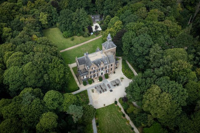 Een dronefoto van het Maarten Maartenshuis op Landgoed Zonheuvel omringd door groene bomen