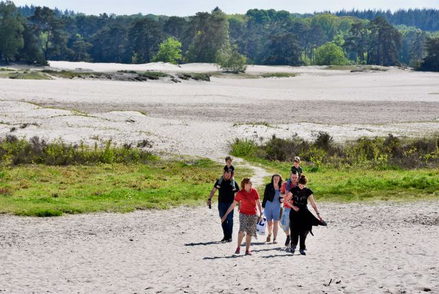 Gezin wandelt in de Soesterduinen met hun hond