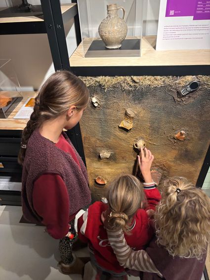 Interactieve archeologietentoonstelling in Bibliotheek Woerden, Groene Hart. Kinderen onderzoeken bodemvondsten en Romeinse scherven bij een educatieve expositie over de Limes, UNESCO Werelderfgoed en de Romeinse geschiedenis van Woerden.