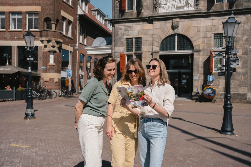 Historische binnenstad Gouda, Zuid-Holland, Groene Hart. Bezoekers bekijken een stadsplattegrond op een plein voor monumentale bebouwing en ontdekken bezienswaardigheden tijdens een dagje uit in de kaasstad.