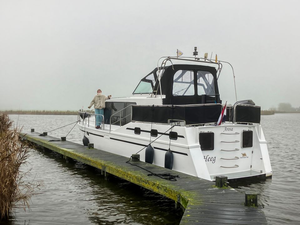 Boot ligt aangemeerd aan steiger in de winter.