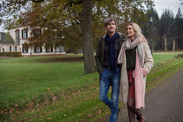 Man en vrouw lopen samen door Veenhuizen in de herfst.