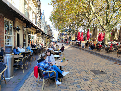 Een terras vol mensen op de beestenmarkt in Delft in de herfst