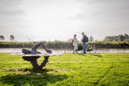 Fietsers bij het standbeeld voor Maarten van der Weijden in Birdaard