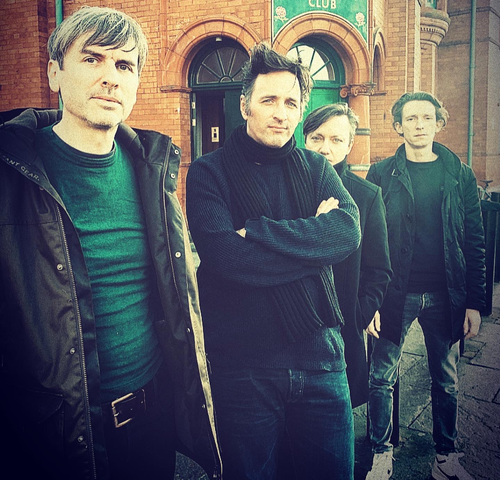 Een band van mannen die voor een gebouw staan