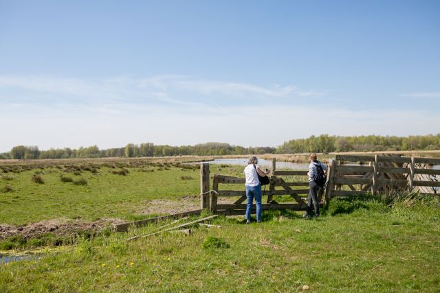 Twee wandelaars die naar dieren zitten te kijken in het Ilperveld