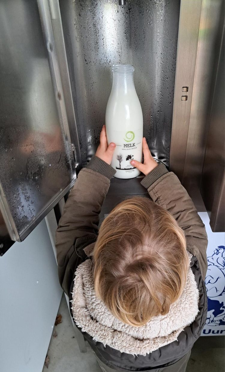 Jongetje met fles zelfgetapte melk bij Koeientuin Tierelier in Heukelom