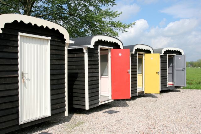 Rij met kleurrijke Veldhuysjes bij Kameryck, kleine overnachtingshuisjes met open deuren in het Groene Hart.