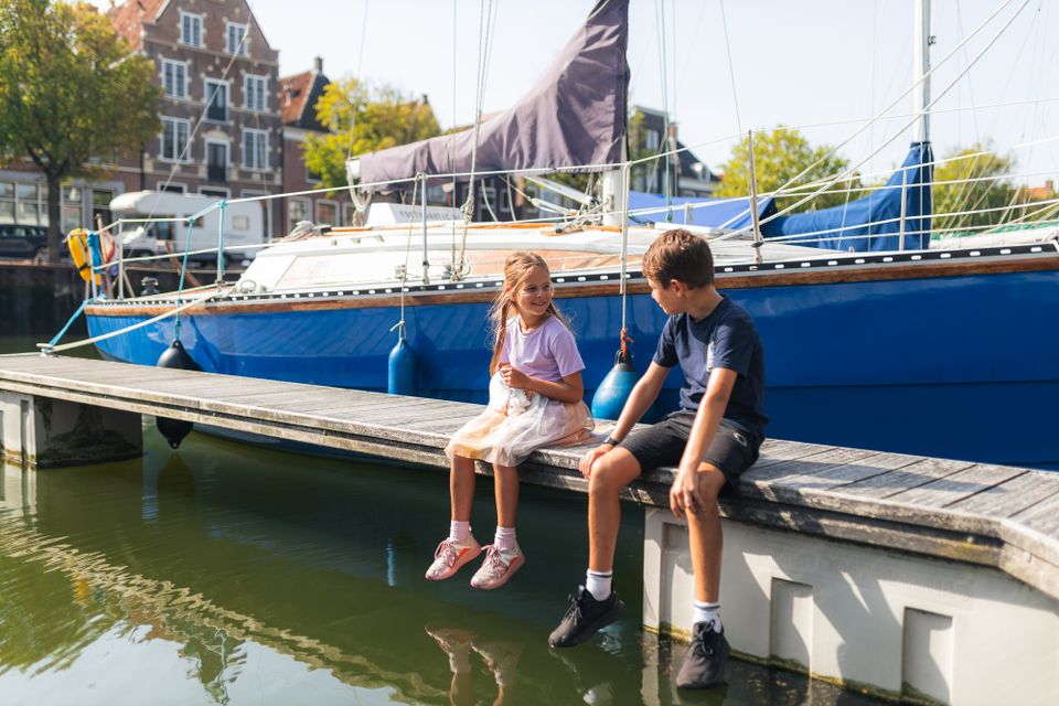 Kinderen zitten op steiger in Harlingen