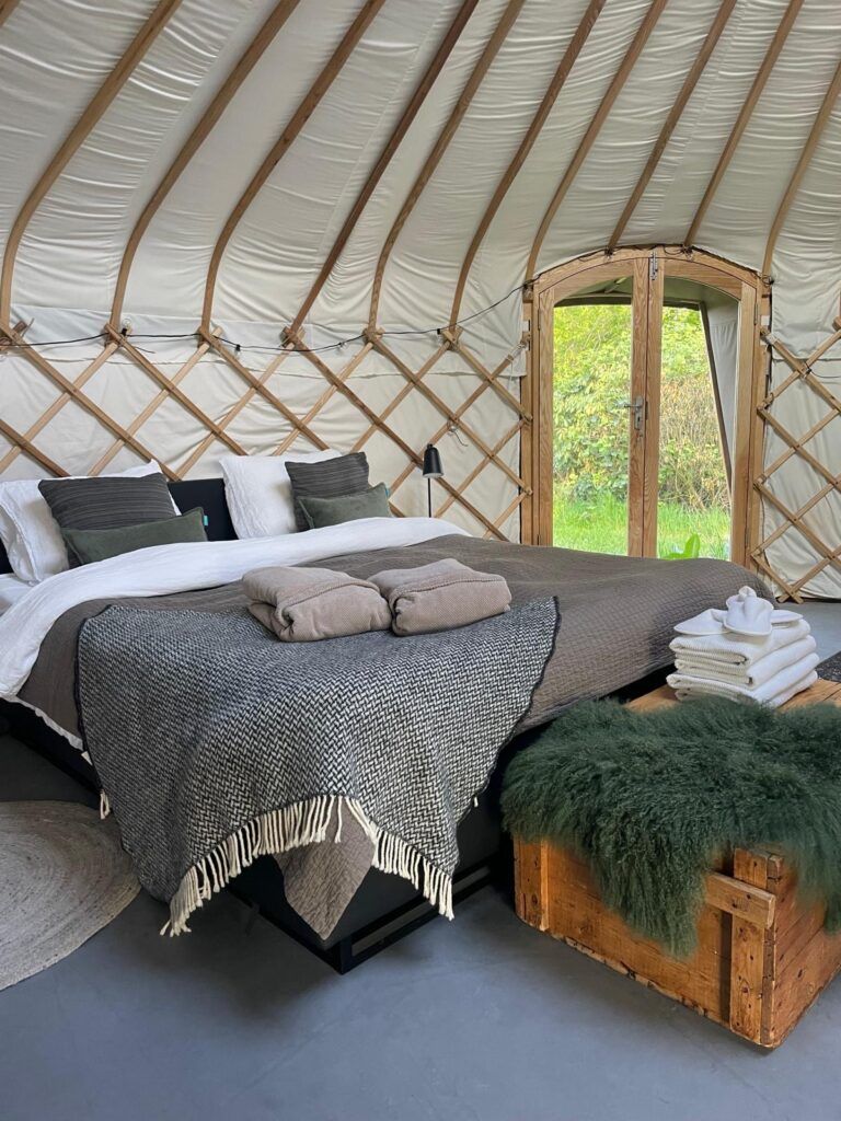 De slaapkamer van de Yurt met een mooi, opgemaakt tweepersoosnbed
