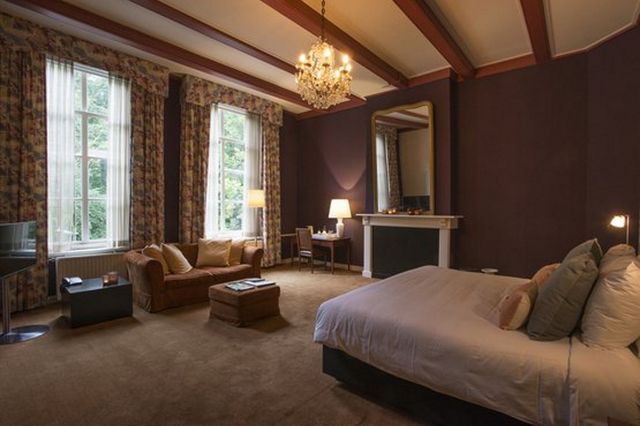 Een hotelkamer met kroonluchter in een chateau.