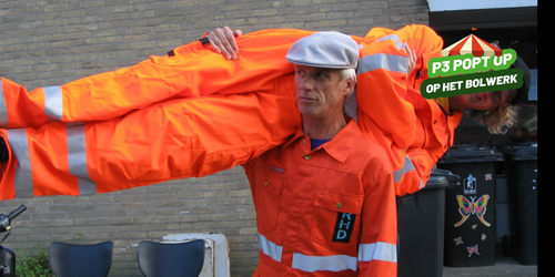 2 vuilnismannen in oranje kleding, de een tilt de ander op.