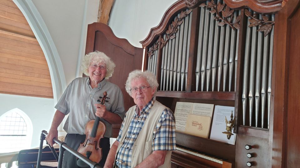 Jannes van de Velde en Hans van den Boomen voor het kabinetorgel van het oude kerkje in Middelbeers