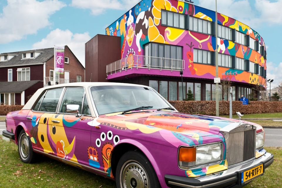 Ein im Toyism-Stil gemaltes Hotel mit einem Auto im Vordergrund im gleichen Stil.