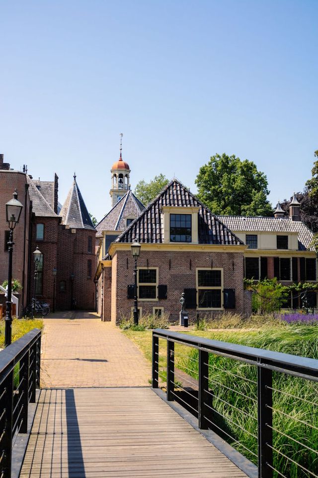 Im Vordergrund eine Brücke, die zu historischen Gebäuden in der Innenstadt von Assen in Drenthe führt.