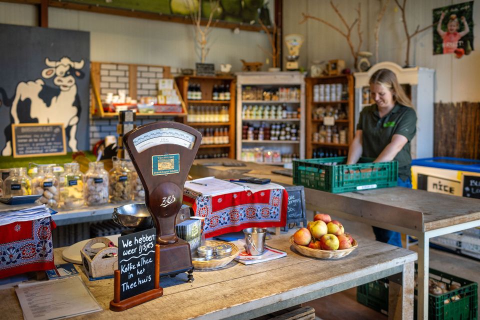 Boerderijwinkel Nieuw Slagmaat in Bunnik, Kromme Rijnstreek, met medewerker achter de toonbank, verse appels, ouderwetse weegschaal en schappen met streekproducten.