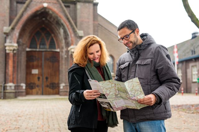 Twee mensen die een routekaart lezen voor een klooster