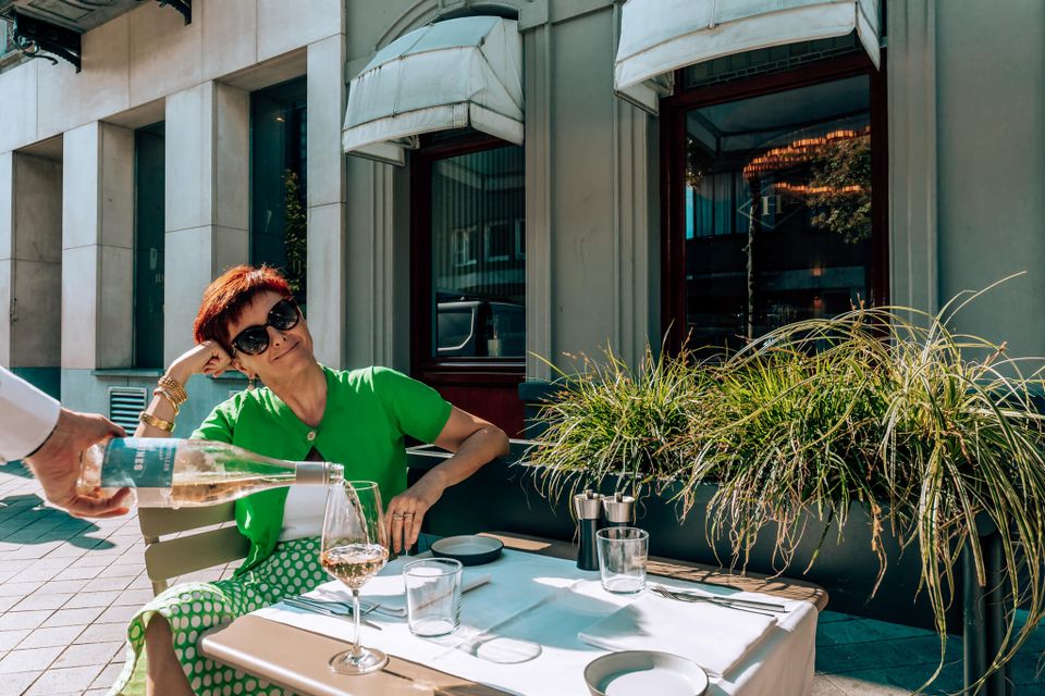 Chazia Mourali on terrace pouring Harry's Maastricht wine