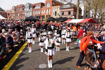 Evenement Koningsdag Woerden, Kerkplein, Groene Hart, majorettes en fanfare tijdens feestelijke viering met publiek en oranje accenten op het plein.