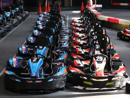 Blauwe en rode kartwagens op een rij bij Game city in Zoetermeer.