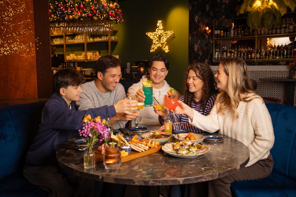 Gezin geniet van het eten en drinken bij Mace