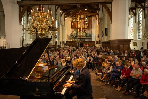 Iemand die op een piano speelt in de kerk