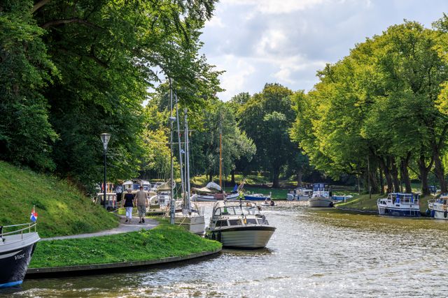 Foto van de prinsentuin in Leeuwarden met aangemeerde bootjes aan de weerskanten van het water.