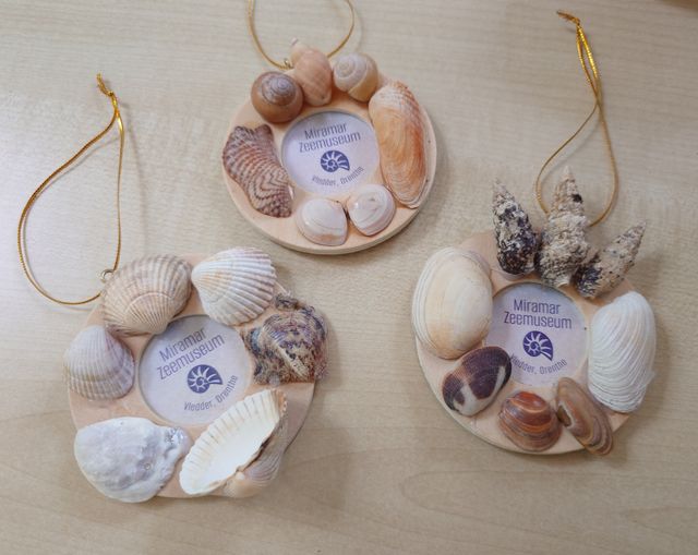 Drie kleine fotolijstjes zijn versierd met schelpen
