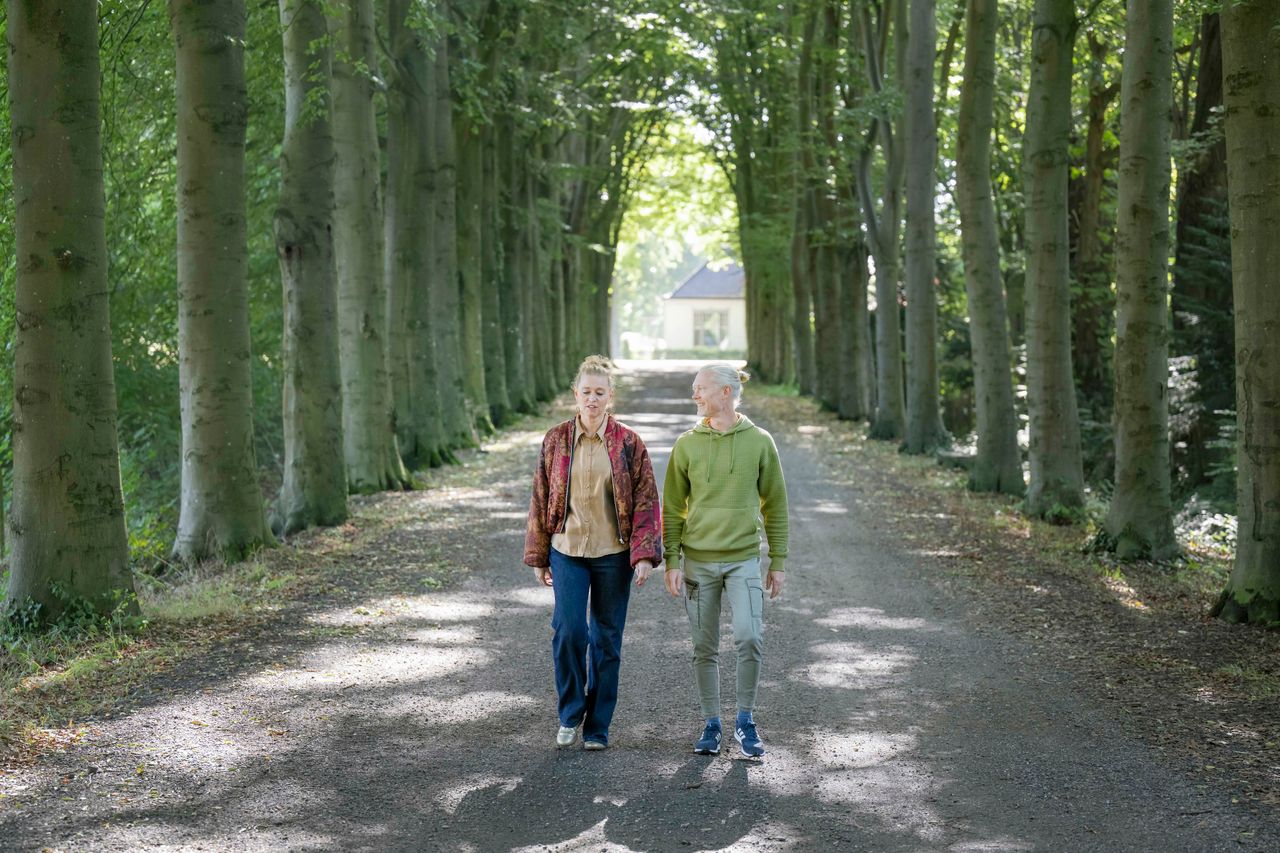 Dame en heer wandelend over de Molenlaan in Frederiksoord.