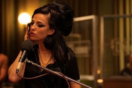 Een still uit de film Back to Black met daarop de actrice die Amy Winehouse speelt achter een microfoon