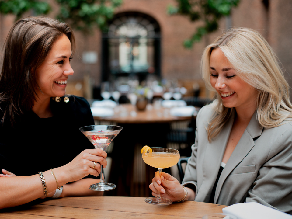 Meiden met een cocktail op het terras van Hotel Arsenaal