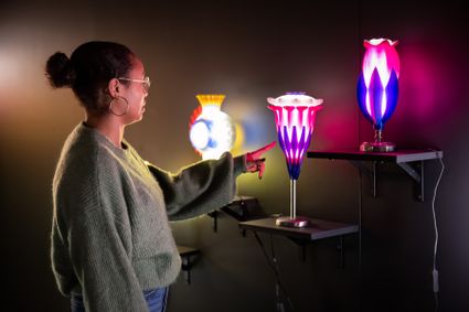 Een bezoeker in Museum de Tiid in Bolsward bij een tentoonstelling met kleurrijke lampen tijdens de Open Museum Maand 2025.