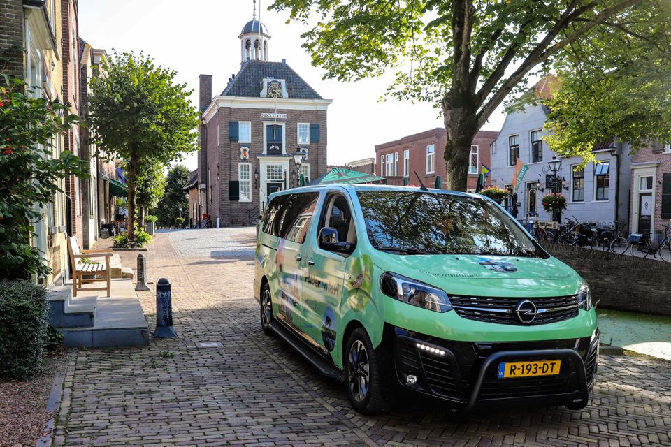 Een groen busje op straat geparkeerd