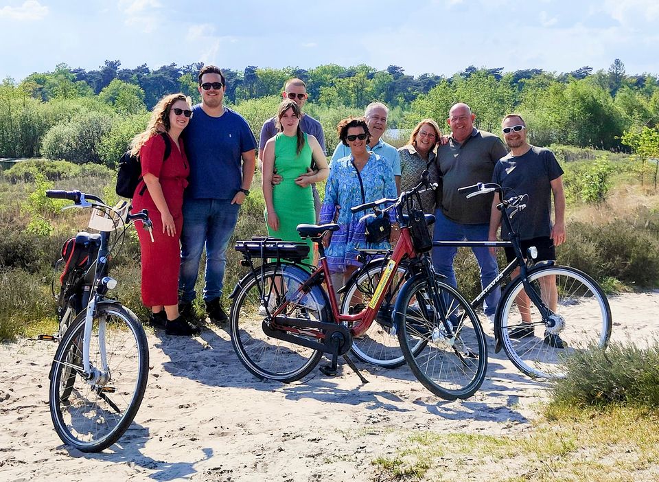 Groep fietsers poseert voor de heide van natuurgebied Kampina