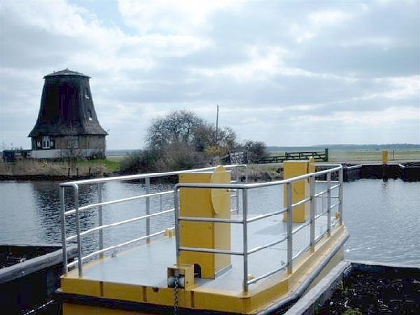 Een fraaie foto van de pont met de molen op de achtergrond.