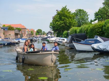Gezin vaart in boot door Leerdam