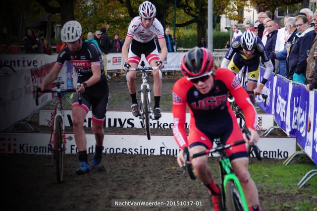 Wielercross tijdens de Nacht van Woerden in Woerden, Groene Hart. Wielrenners springen met hun cyclocrossfietsen over hindernissen op een modderig parcours, terwijl toeschouwers langs de kant de wedstrijd volgen.