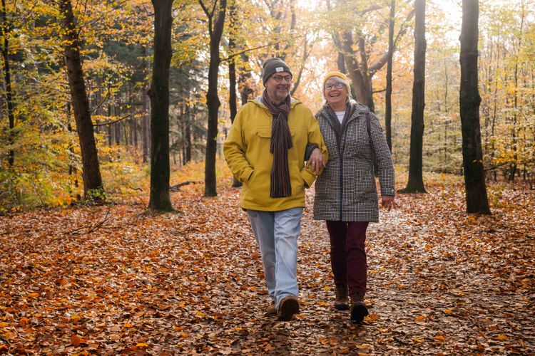 Twee oudere mensen aan het wandelen in een herfstig stadsbos013