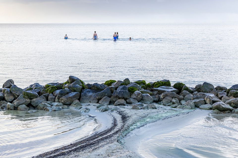 een groep vrouwen loopt het water in