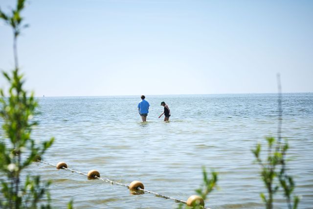 Een man en een vrouw pootjebaden bij het strandje van Mirns.